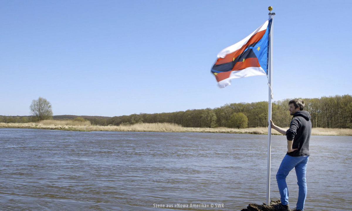 Bild eines Mannes an einem Ufer mit Fahne