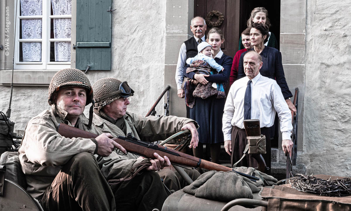 Filmstill aus dem SWR Dokudrama "Unbekannte Helden": Soldaten fahren an einer Familie vorbei (© SWR / Stegmann)