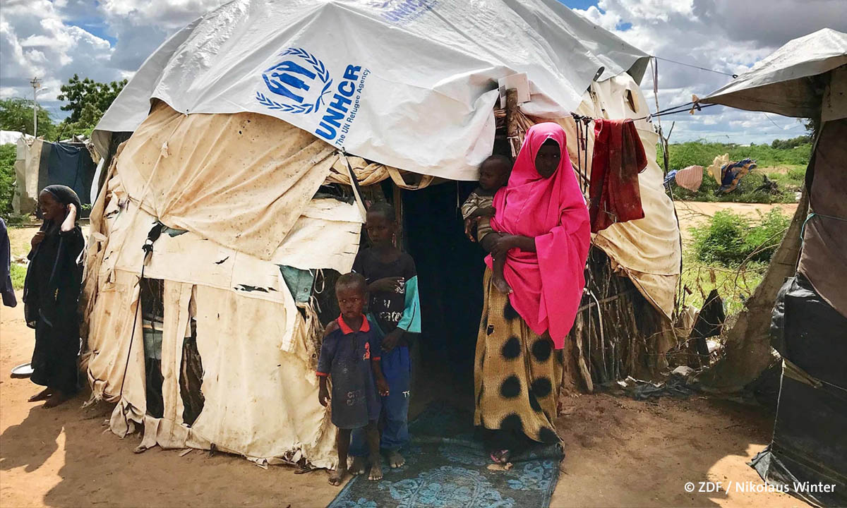 Filmstill aus der ZDF-Doku "Unantastbar": Foto einer Familie vor ihrem Zelt in einem Flüchtlingslager (© ZDF/Nikolaus Winter)