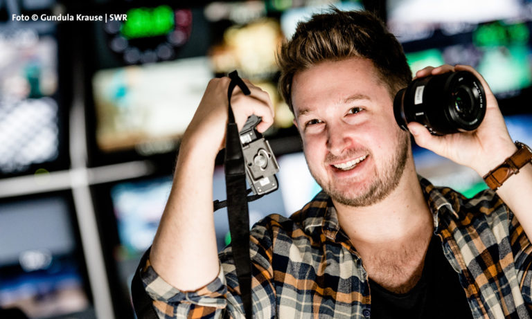 Bild: Junger Mann mit Film-Equipment in der Hand