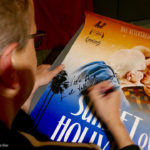 Mann signiert Kinoposter