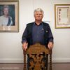 Mann neben Portrait von Königin Elizabeth II