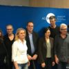Bild von mehreren Personsn vor einer blauen Wand