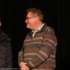 Bild mehrerer Personen mit Mikrofon vor einer Leinwand