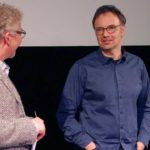 Zwei Männer vor einer Leinwand im Gespräch