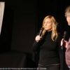 Frau und Mann mit Mikrofon vor einer Kinoleinwand