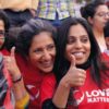 Mehrere Frauen in roten T-Shirts geben ein Thumbs Up