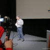 Bild: Kay Hoffmann mit Mikrofon vor einer Leinwand