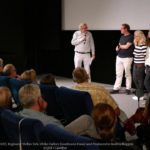 Bild mehrerer Personen vor einer Leinwand