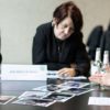 Bild von mehreren Personen die an einem Tisch arbeiten