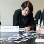 Bild von mehreren Personen die an einem Tisch arbeiten