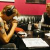 Bild zweier Männer am Tisch mit Gitarre