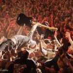 Bild eines Gitarristen beim Crowdsurfing während eines Konzertes