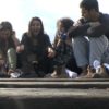 Bild von sitzenden Jugendlichen auf Eisenbahnenschienen