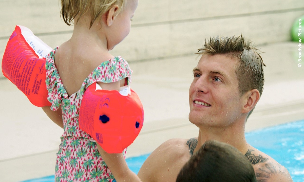 Filmstill aus Dokumentarfilm "Kroos": Kroos mit einem kleinen Kind im Schwimmbecken (© Broadview Pictures)