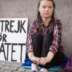 Greta Thunberg sitzt während ihres Schulstreiks vor einem Gebäude. (Foto: B-Reel Films)