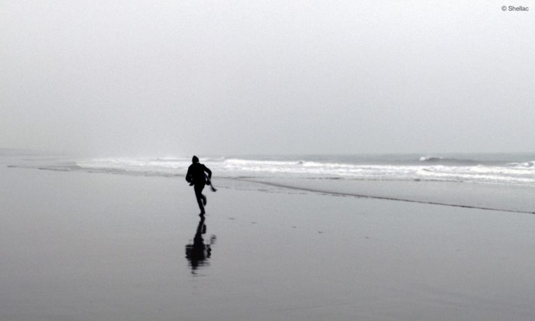 Ein Mann rennt am Strand entlang. Filmstill aus "Wohin, Flüchtling?" (c) Shellac