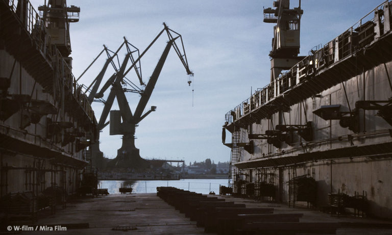 Filmstill aus „Der nackte König – 18 Fragmente über Revolution“, zu sehen ist eine Industrieanlage am Wasser(Foto: W-Film/Mira Film)