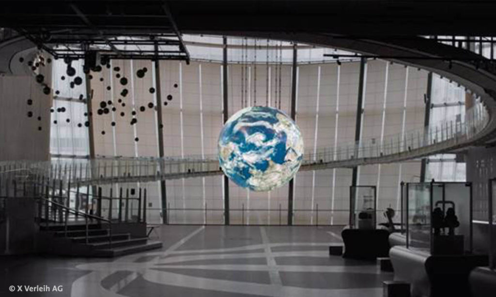 Filmstill Foyer mit Weltkugel aus dem Berlinale-Film "Wer wir waren" von Marc Bauder