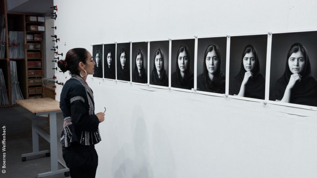 Künstlerin Shirin Neshat vor Fotowand.