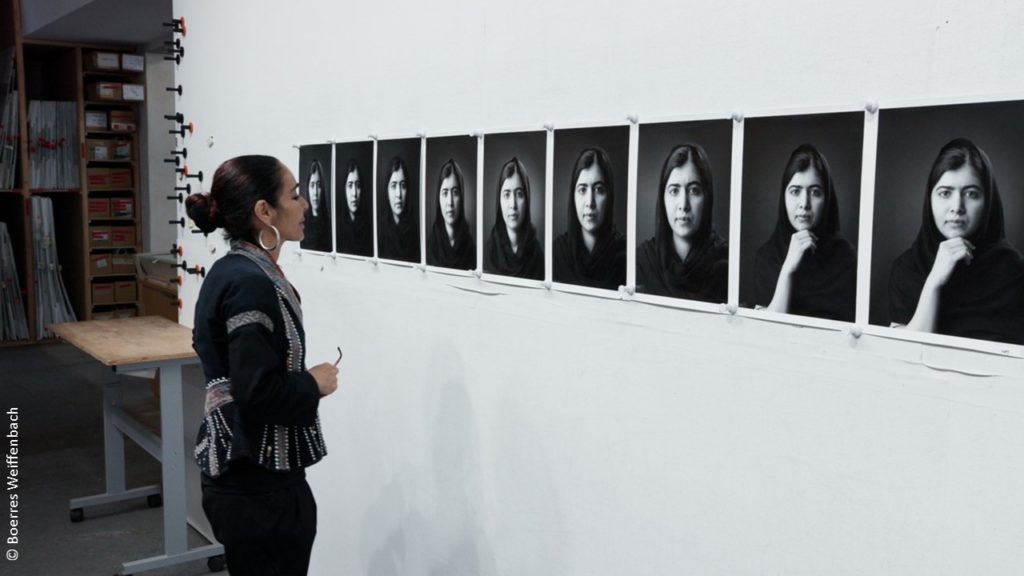 Künstlerin Shirin Neshat vor Fotowand.