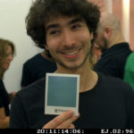 Filmstill: An Impossible Project: Oskar Smolokowski, Chef von Impossible, hält ein Polaroid in die Luft, auf dem noch kein Bild zu sehen ist © 2020 Weltkino