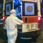 COVID 19 - Menschen an Krankenwagen