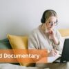 Frau mit Kopfhörern und Laptop auf Bett