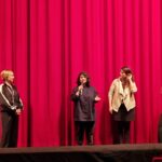 Frauen vor Kinovorhang v.l.n.r.: Moderatorin, Helin Celic, Rebeca Sánchez López und Raquel Fernández Núñez.