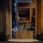Filmstill aus ROBIN BANK. Zu sehen ist ein mutmaßlich kaputter Geldautomat, der mit antikapitalistischen Graffitis beschmiert ist © Camino Filmverleih