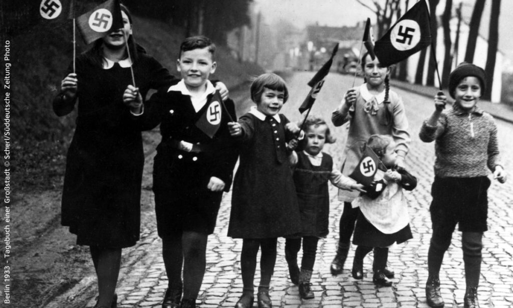 Kinder halten Fahnen mit Hakenkreuzt in Berlin 1933